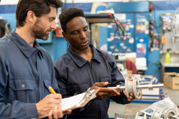 istock Black manual worker showing supervisor a spare part for a water pump engine while he takes notes on clipboard 1198074883