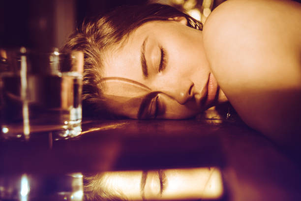 Girl rests her head on the table, eyes closed