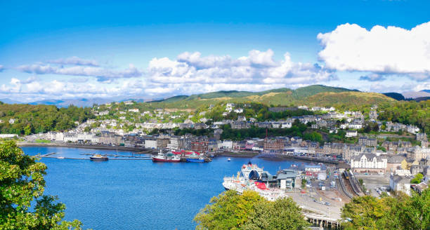 A panoramic view of Oban on the west coast of Scotland A panoramic view of Oban on the west coast of Scotland, showing the town, ferry terminals and hills in  the background, taken on a sunny day in early autumn oban stock pictures, royalty-free photos & images