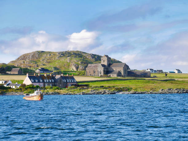 Iona Abbey, cottages and a fishing boat on a sunny day Iona Abbey, cottages and a fishing boat on a sunny day in Autumn from the Sound of Iona. argyll and bute stock pictures, royalty-free photos & images