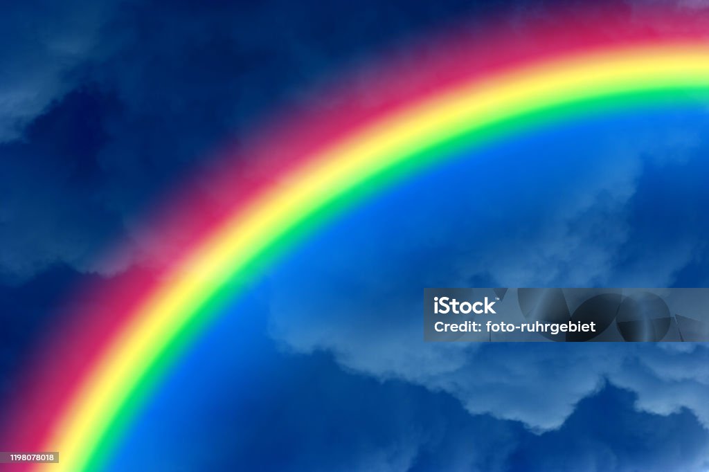 rainbow Under dark blue clouds shines a rainbow. Ark Stock Photo