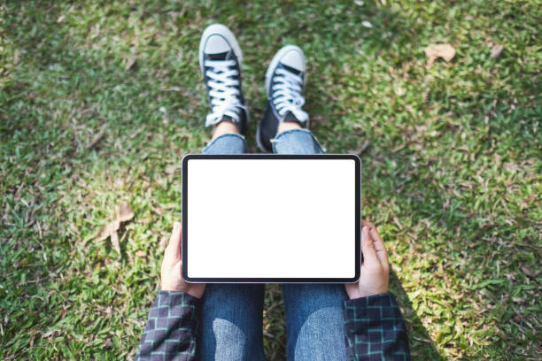 istock a woman holding and using black tablet pc with blank white desktop screen while sitting in the outdoors 1198078035