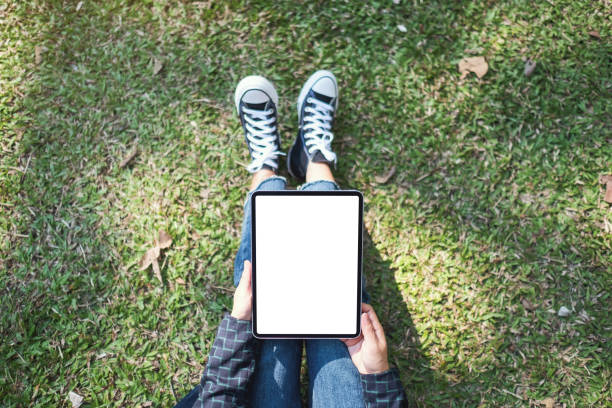 istock a woman holding and using black tablet pc with blank white desktop screen while sitting in the outdoors 1198078037