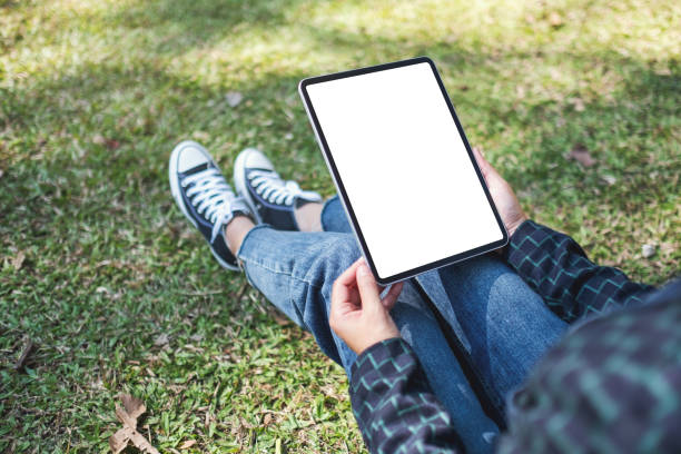 istock a woman holding and using black tablet pc with blank white desktop screen while sitting in the outdoors 1198078080
