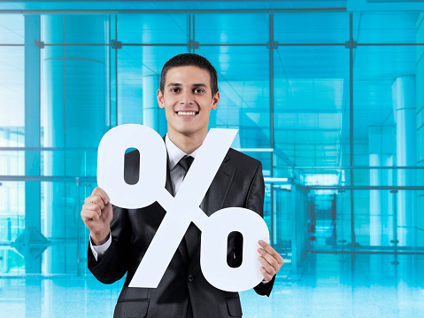 businessman holding percent sign in a modern office