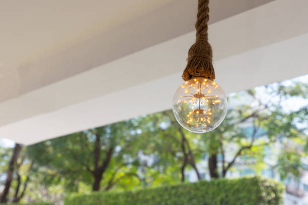 istock vintage light bulb with green tree background. concept : saving energy for world. 1198078639