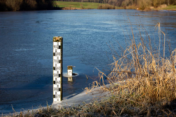 Two water level meters, one in a frozen lake and the other on a lakeshore
