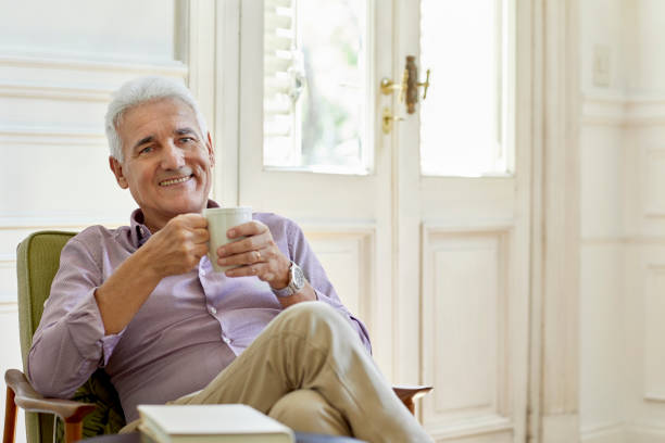 istock Smiling senior man holding coffee cup at home 1198080658
