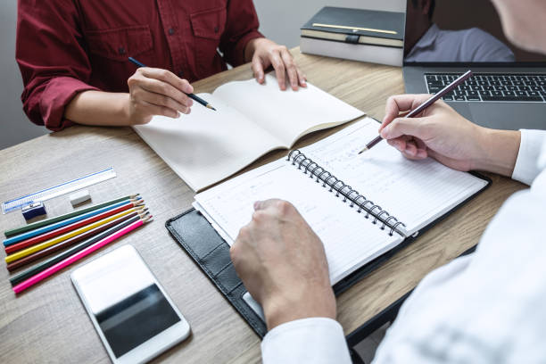 istock Tutor books with friends education, Group students studying and teaching helping and study course with books in library for learning tutoring homework a test or exam 1198080681