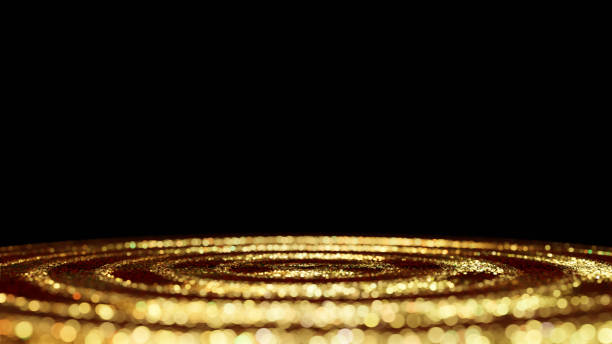 ondas circulares de brillo dorado centelleante iluminado por una luz brillante delante de un fondo negro - spot lit fotografías e imágenes de stock