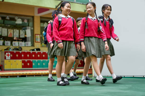 istock Smiling school friends walking together in campus 1198081463