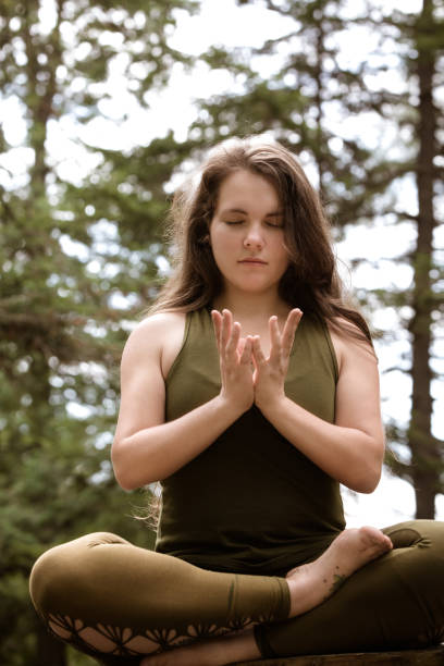 istock Young Woman Relaxing And Meditating Doing A Mudra In Nature 1198082095