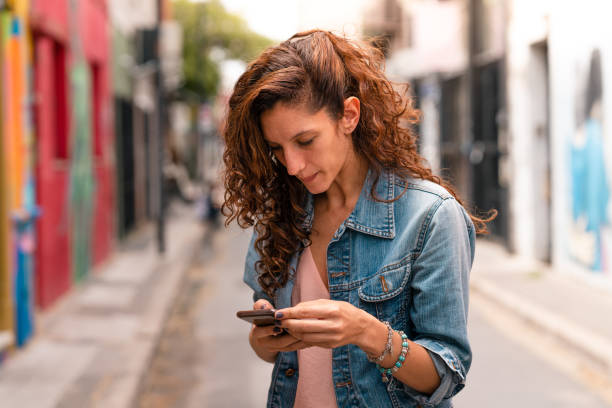 istock Confident young woman using her smart phone 1198086590