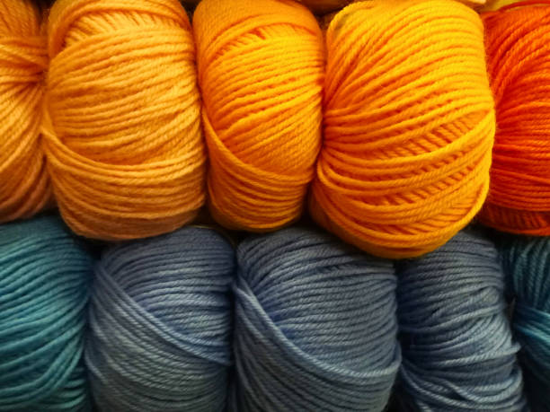 Blue, gray and brown balls of knitting thread on a blue background for hobbies. Flat lay