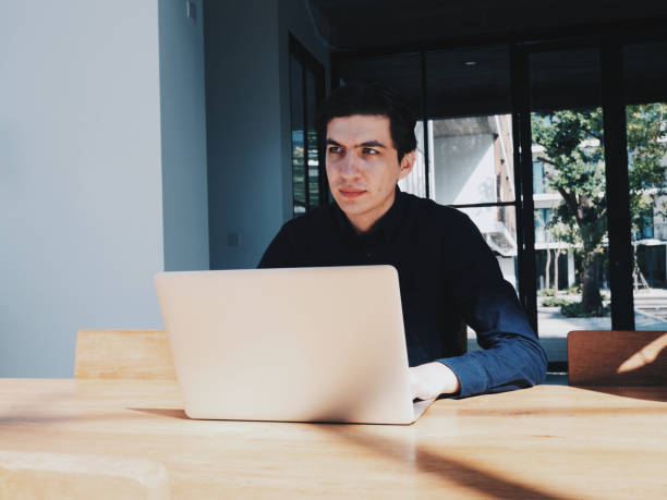 istock Young handsome guy working on his laptop in coworking space at sunny day 1198087096