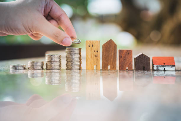 Hand choosing row of coin money on wood table and mini wood house, selective focus, Planning to buy property. Choose what's the best. A symbol for construction ,ecology, loan concepts elección a mano de la fila de dinero de la moneda en la mesa de madera y mini casa de madera, enfoque selectivo, planificación para comprar la propiedad. elige lo que sea mejor. un símbolo para la construcción, la ecología, los conceptos de préstamo