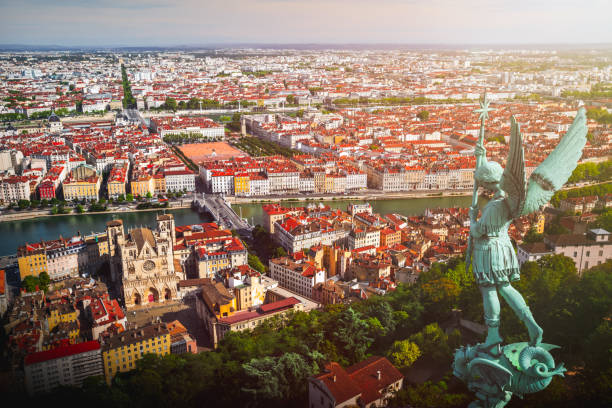 Awesome aerial view on Lyon French cityscape viewed from the roofs of Basilica Notre Dame de Fourviere with Archangel Michael statue overlooking the city Awesome aerial view on Lyon cityscape, with Saint Jean-Baptiste Cathedral, both Saone and Rhone river, with Bonaparte bridge, famous place Bellecour and typical red roofs from apartment residential buildings. High angle view of Lyon viewed from the roofs of Basilica Notre Dame de Fourviere with verdigris Archangel Michael statue overlooking the city. The Basilica was built between 1872 and 1884, dedicated to the Virgin Mary. This image was taken during a sunny summer day in Lyon city in Rhone department, Auvergne-Rhone-Alpes region in France (Europe), outside Basilica Notre Dame de Fourviere, on Fourviere hill. fourviere stock pictures, royalty-free photos & images