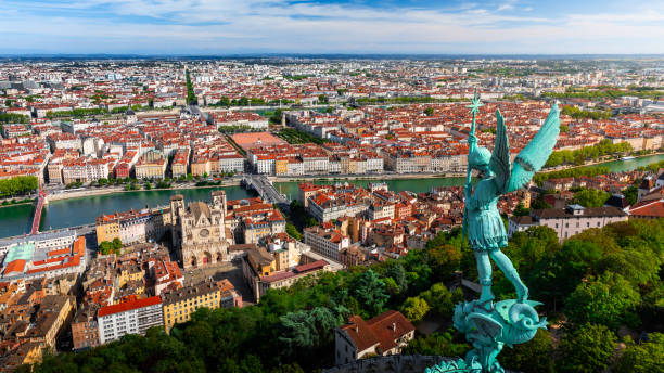 Awesome aerial view on Lyon French cityscape viewed from the roofs of Basilica Notre Dame de Fourviere with Archangel Michael statue overlooking the city stock photo