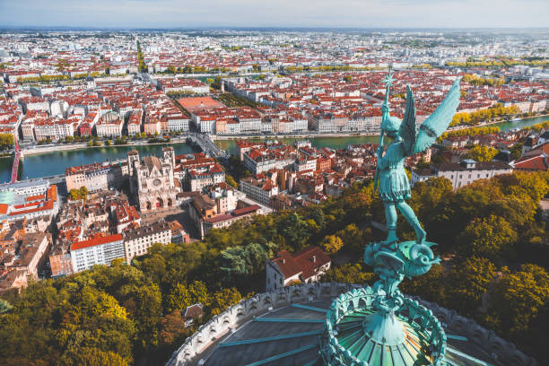 Awesome aerial view on Lyon French cityscape viewed from the roofs of Basilica Notre Dame de Fourviere with Archangel Michael statue overlooking the city stock photo