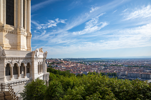 High angle view of the famous Croix Rousse district with red roofs viewed from the Basilica Notre Dame de Fourviere built between 1872 and 1884, in a dominant position overlooking the city of Lyon, and dedicated to the Virgin Mary. This image was taken during a sunny summer day in famous Lyon city in Rhone department, Auvergne-Rhone-Alpes region in France (Europe), outside Basilica Notre Dame de Fourviere, on Fourviere hill.