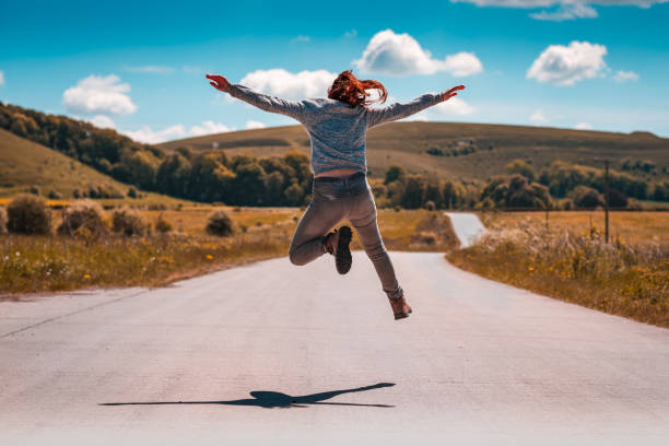 istock Girl jumping on road 1198090998