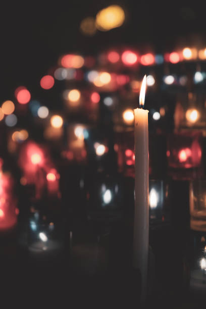 Focus on large group of red, white and blue illuminated prayer candles in a row in catholic Basilica Notre Dame de Fourviere in Lyon French city Selective focus on a large group of red, white and blue color illuminated prayer candles, dark, in a row in catholic Basilica Notre Dame de Fourviere. The Basilica was built between 1872 and 1884 with Byzantine and Romanesque architecture style, in a dominant position overlooking the city of Lyon, and dedicated to the Virgin Mary. It features fine mosaics and superb stained glass very ornate with gold and some paintings on the ceiling. This image was taken inside this famous place of worship monument in Lyon city, in Rhone department, Auvergne-Rhone-Alpes region in France (Europe), on Fourviere hill. fourviere stock pictures, royalty-free photos & images