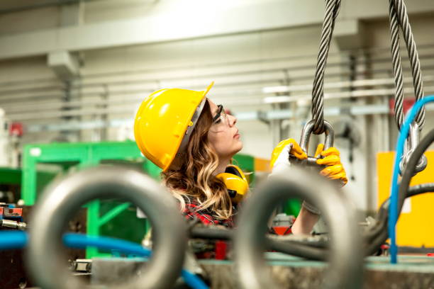 istock Young engineer woman holding and working with cable winch for operating crane 1198092430