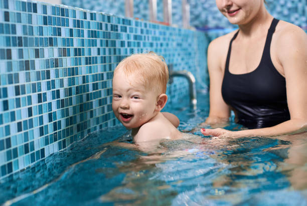istock Mother with baby in swimming pool training 1198092916