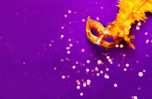 Máscara de carnaval sobre fondo púrpura con destellos. Telón de fondo festivo para proyectos. Primer plano photo
