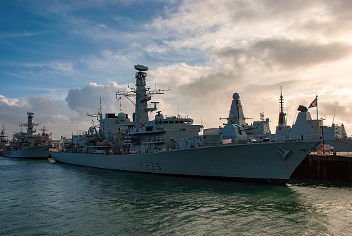 Navy frigate enters a harbour after offshore training exercises.