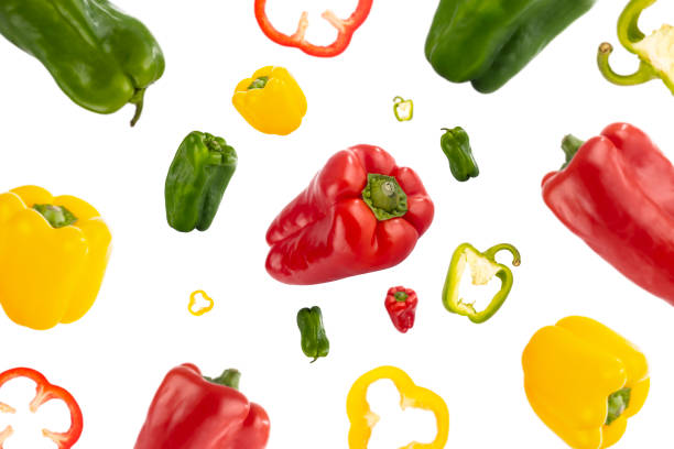 Healthy red, green and yellow peppers flying through the air stock photo