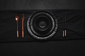 Black dishes with bamboo cutlery and chopsticks. Japanese tableware