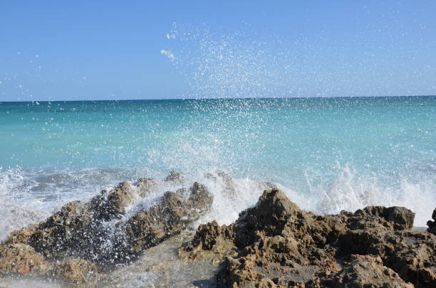 istock blue ocean water splashing on rocks on the beach 1198105386