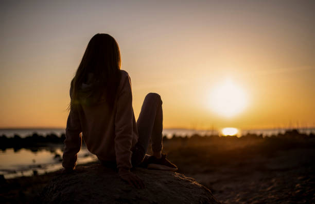 istock girl looking at sunset 1198105392