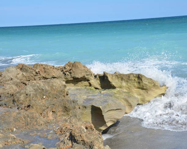 istock blue ocean water splashing on rocks on the beach 1198105454