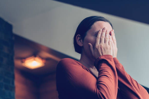 mujer deprimida cubriendo la cara con las manos y llorando - pessimist women one person caucasian fotografías e imágenes de stock