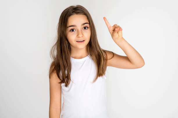 istock Little girl pointing finger up 1198112530