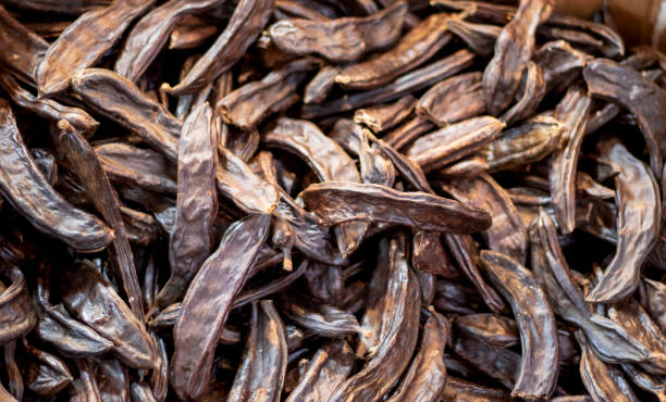 carob food is sweet and healthy. photographed in dried fruits store. - ceratonia imagens e fotografias de stock