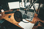 Radio station microphone in recording studio or broadcast room, working place of radio host, close up