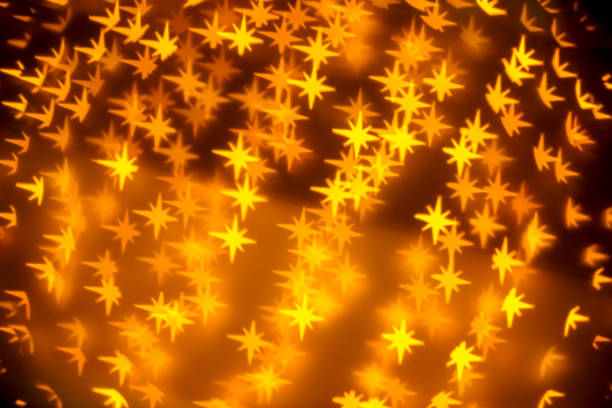 Golden Christmas background - defocused bokeh with a star shape. Space for copy. It's a REAL bokeh photo, not an illustration or computer filter.