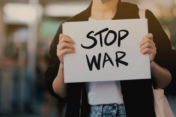 istock Activists raise anti-war message signs 1198117319