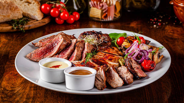 istock Turkish cuisine. Assorted different meat on the grill, lamb, chicken, pork with grilled vegetables. Serving dishes in a restaurant on a white plate. background image, copy space 1198118342