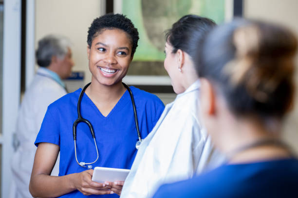 istock Student nurse smiles while talking with fellow nurse 1198122982