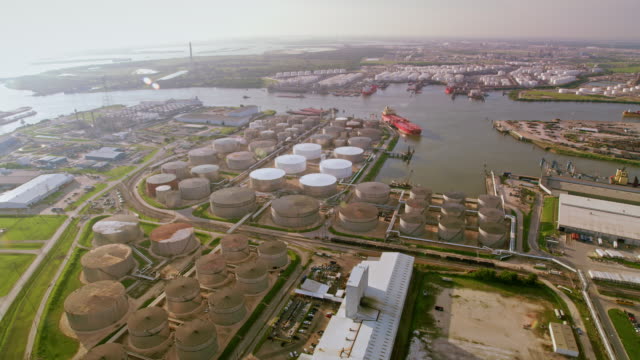 AERIAL Oil refinery storage tanks and cargo ships docked on the river in Houston, TX