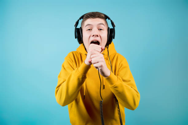 istock a guy in bright clothes and large headphones screams into an imaginary microphone 1198124946