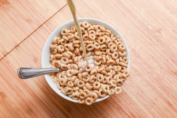 istock Breakfast cereal bowl with cold milk being poured at the morning breakfast table 1198132366