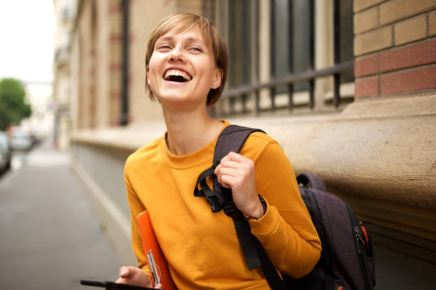 istock female college student with bag laughing outside 1198133900