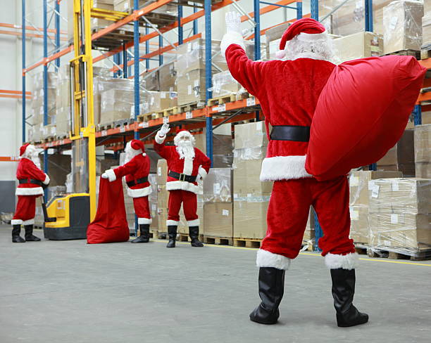 Santas at a warehouse working for Christmas stock photo