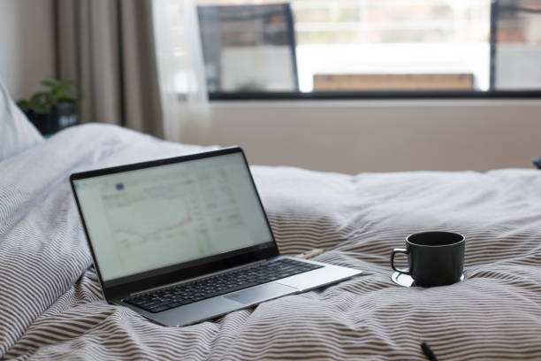 istock Coffee cup and laptop on the bed 1198135852