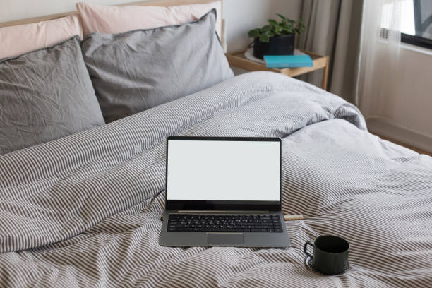 istock Coffee cup and laptop on the bed 1198135854